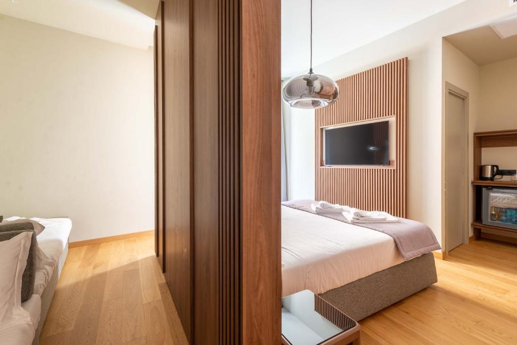 a hotel room with a bed and a tv at ELICAL Exclusive Private Suites in Rome