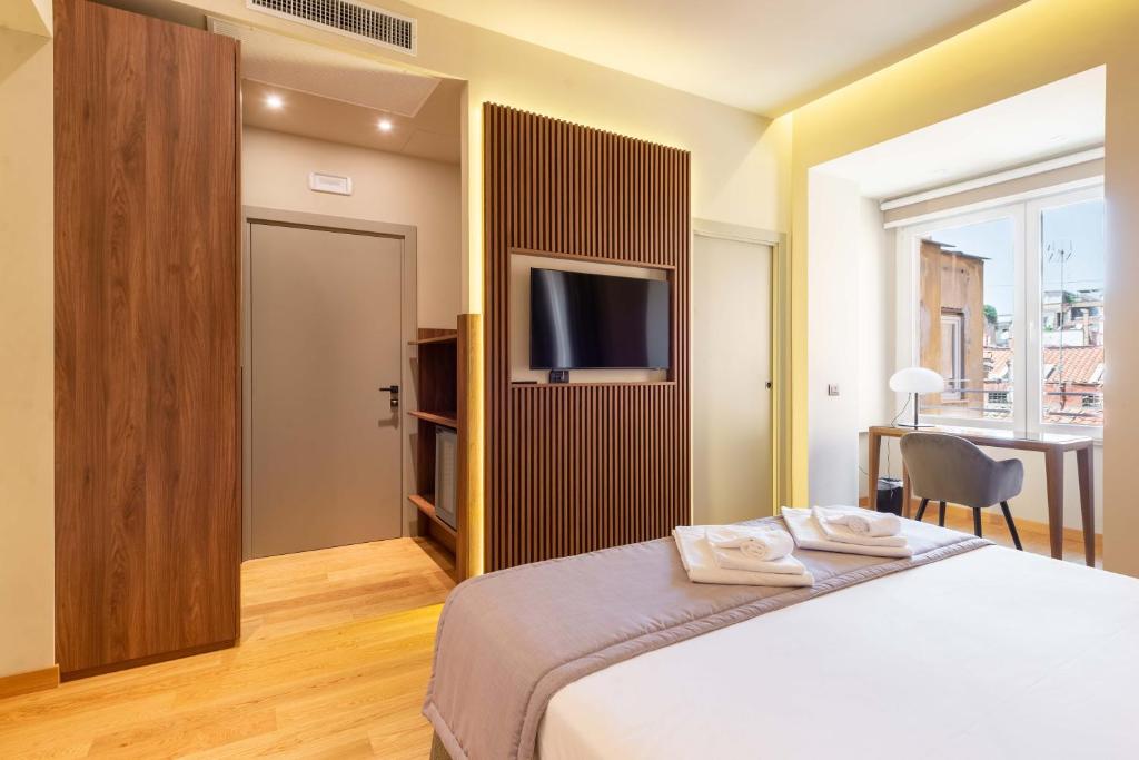 a bedroom with a bed and a flat screen tv at ELICAL Exclusive Private Suites in Rome