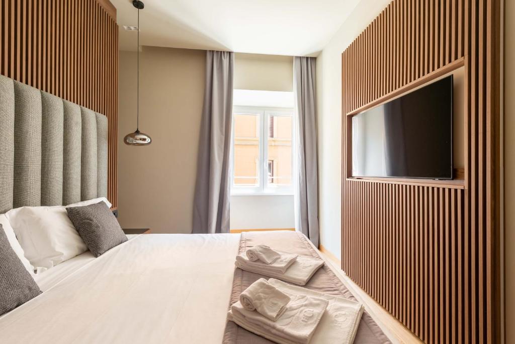a bedroom with a large bed and a flat screen tv at ELICAL Exclusive Private Suites in Rome