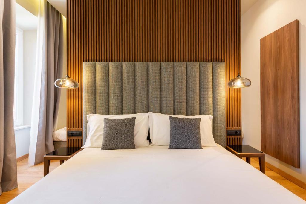 a bedroom with a large white bed with two pillows at ELICAL Exclusive Private Suites in Rome