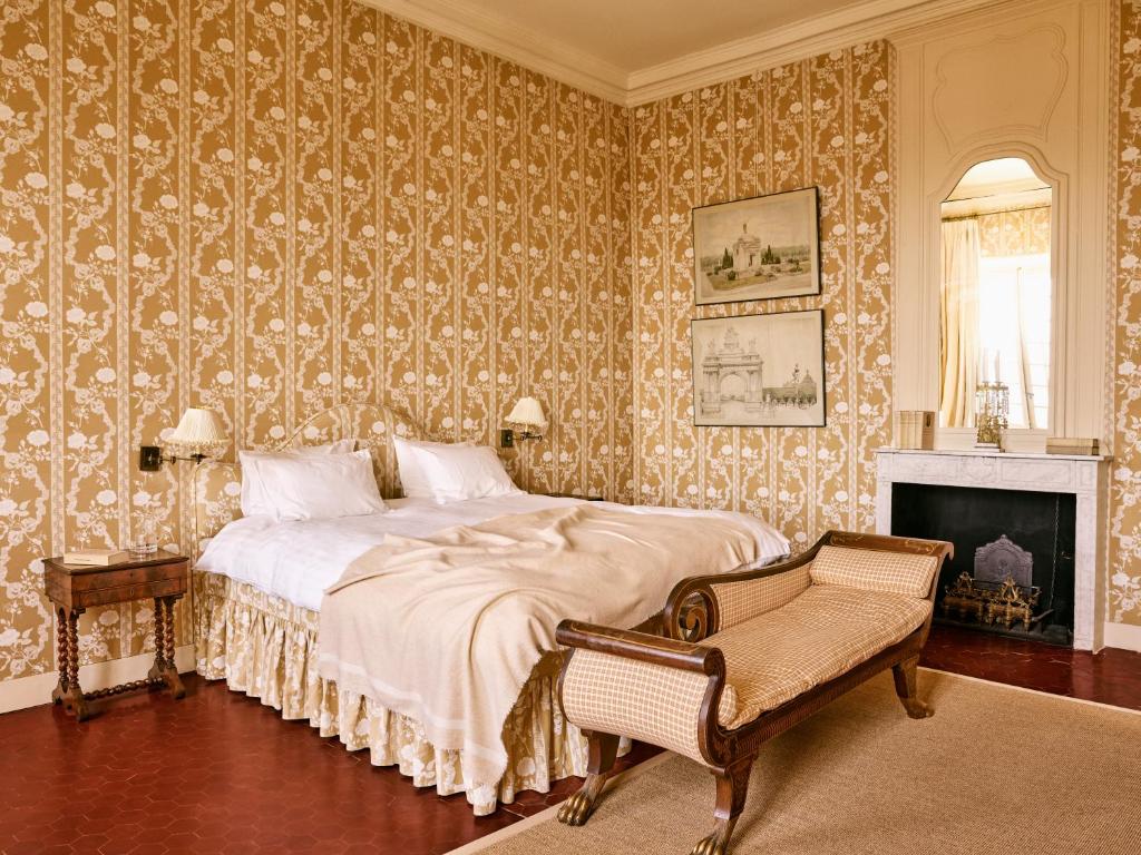 a bedroom with a large bed and a fireplace at Hôtel particulier de Tingry - Pierres d'Histoire in Ménerbes