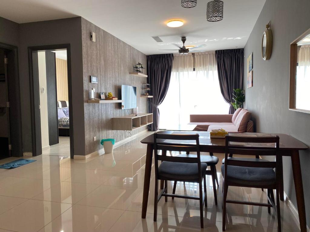 sala de estar con mesa, sillas y sofá en 【NETFLIX】Suasana Suites,Nxt to CIQ【PoolGym&WIFI】, en Johor Bahru