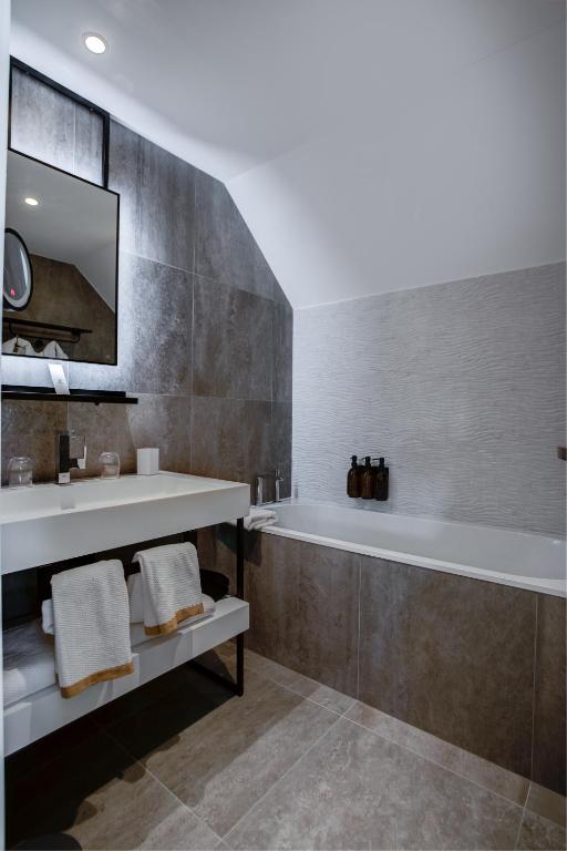 a bathroom with a tub and a sink at Fleur de Loire in Blois