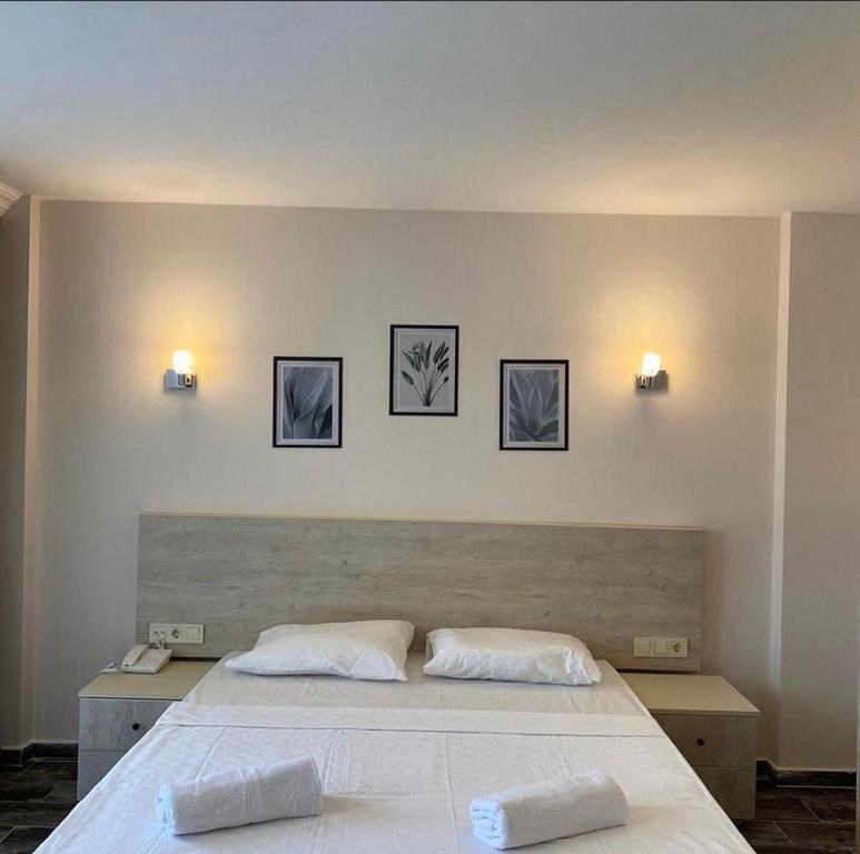 a bedroom with a large bed and three pictures on the wall at Dream Town Hotel&Restaurant in Kemer