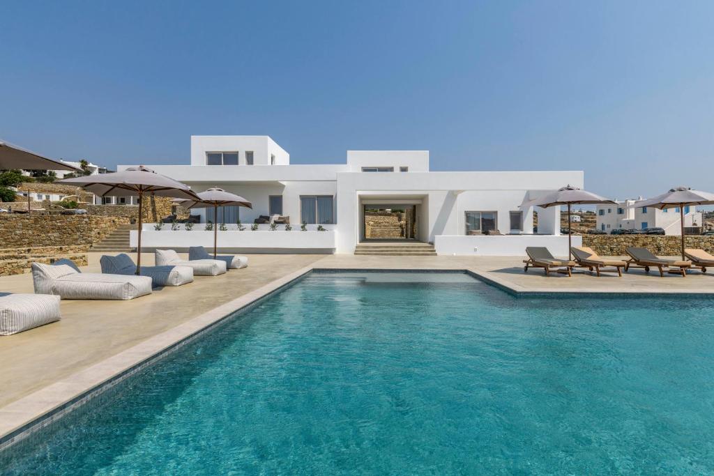 a swimming pool in front of a villa at Muro Suites in Ornos