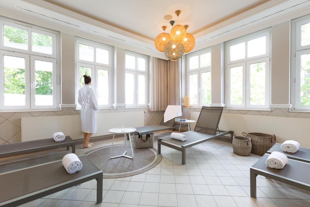 a woman standing in a waiting room with windows at Vju Hotel Rügen in Göhren
