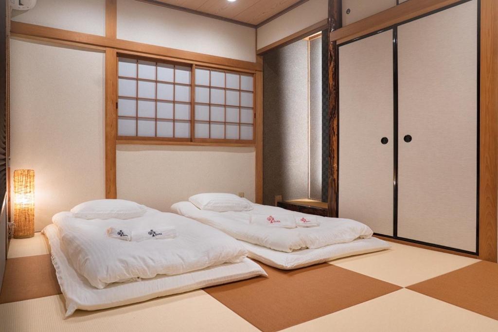 Tempat tidur dalam kamar di HANASTAY花渓居 · 柳（YANAGI)