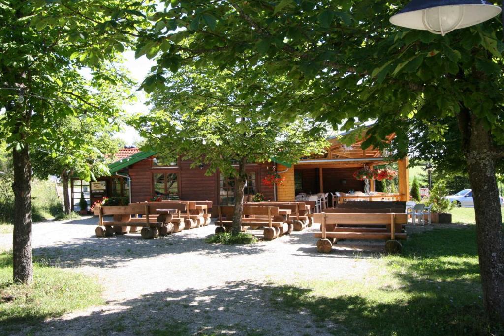 einer Gruppe von Bänken vor einer Kabine in der Unterkunft Ferienpark Lauterdörfle 4 in Hayingen