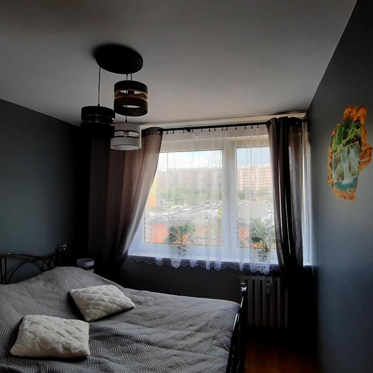 a bedroom with a bed and a window at Apartament Grodzka in Wałbrzych