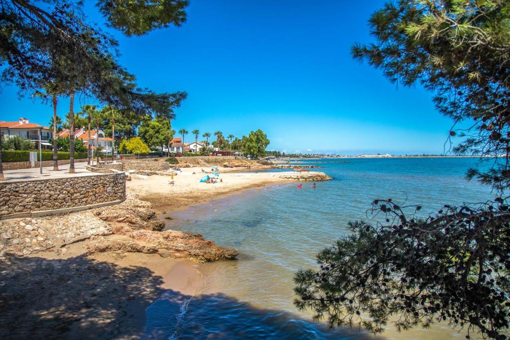 a beach with people on the sand and the water at Apartament La Morra in Sant Carles de la Ràpita