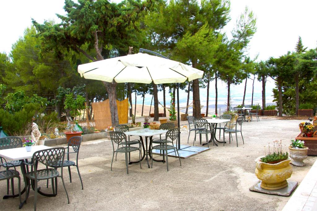 a group of tables and chairs with an umbrella at b&b il villino in Matera
