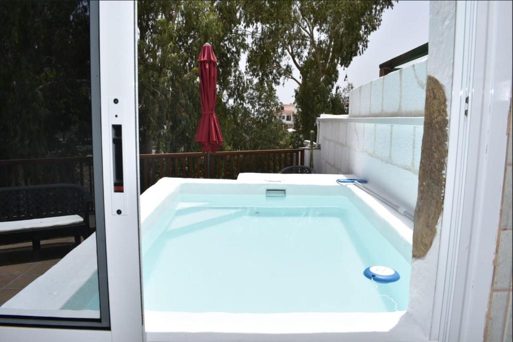 einen Whirlpool auf einem Balkon mit Sonnenschirm in der Unterkunft Holiday Cottage Santa Lucía in Santa Lucía