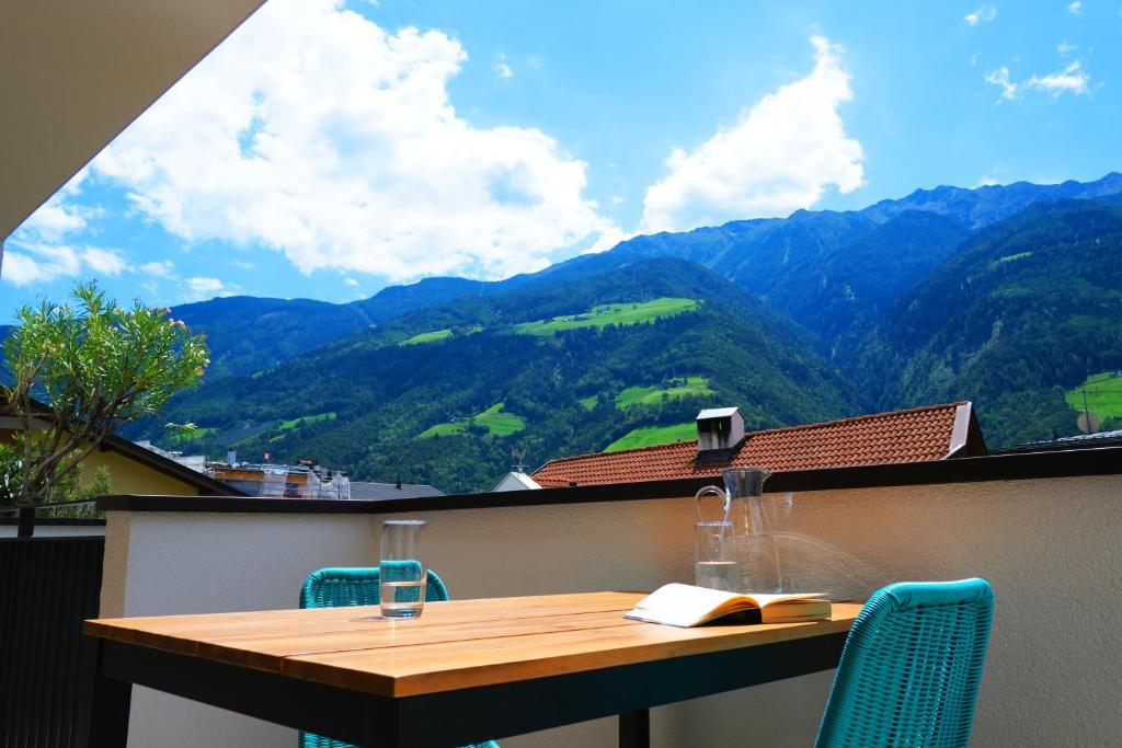 uma mesa numa varanda com vista para as montanhas em Apartment Oleander em Naturno