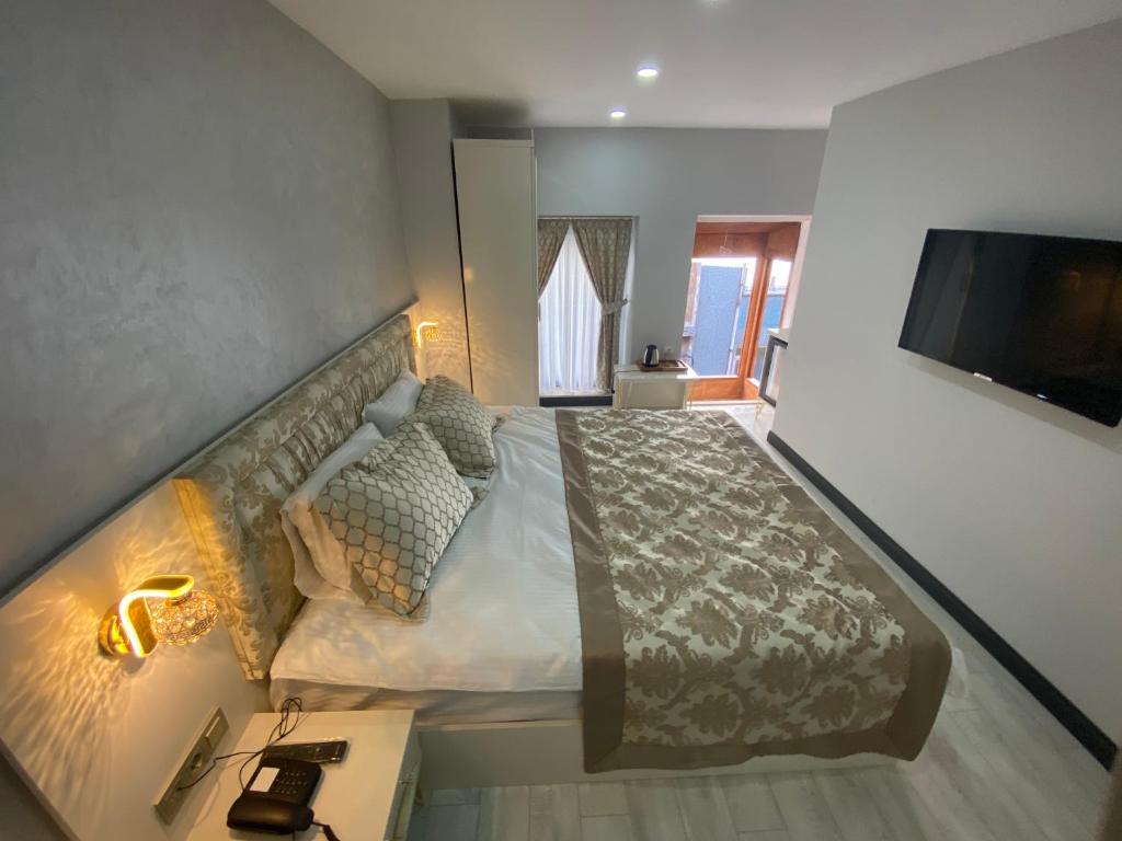 1 dormitorio con 1 cama grande y TV en Şiva Pera Hotel & SPA, en Estambul
