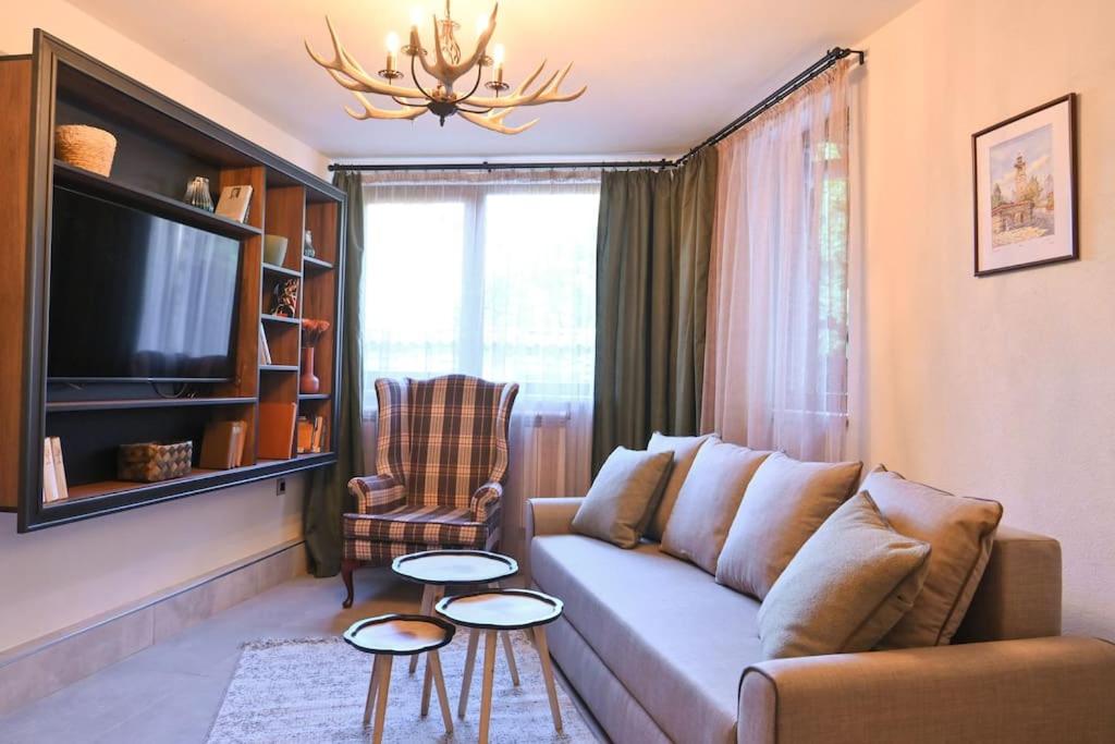a living room with a couch and a tv at Marand Villas in Bansko