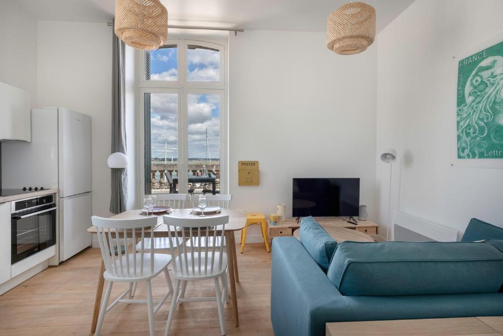 sala de estar con sofá azul y mesa en Charmant appartement vue mer au coeur du Croisic, en Le Croisic
