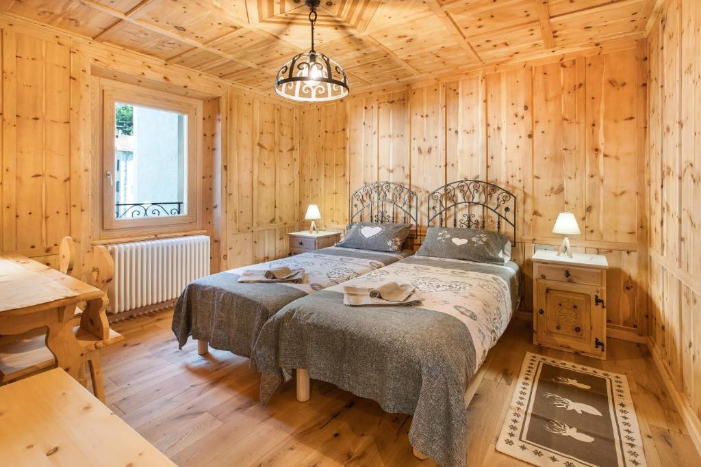 sypialnia z 2 łóżkami w drewnianym domku w obiekcie Casa Cecilia tra Bormio e Livigno w mieście Valdidentro