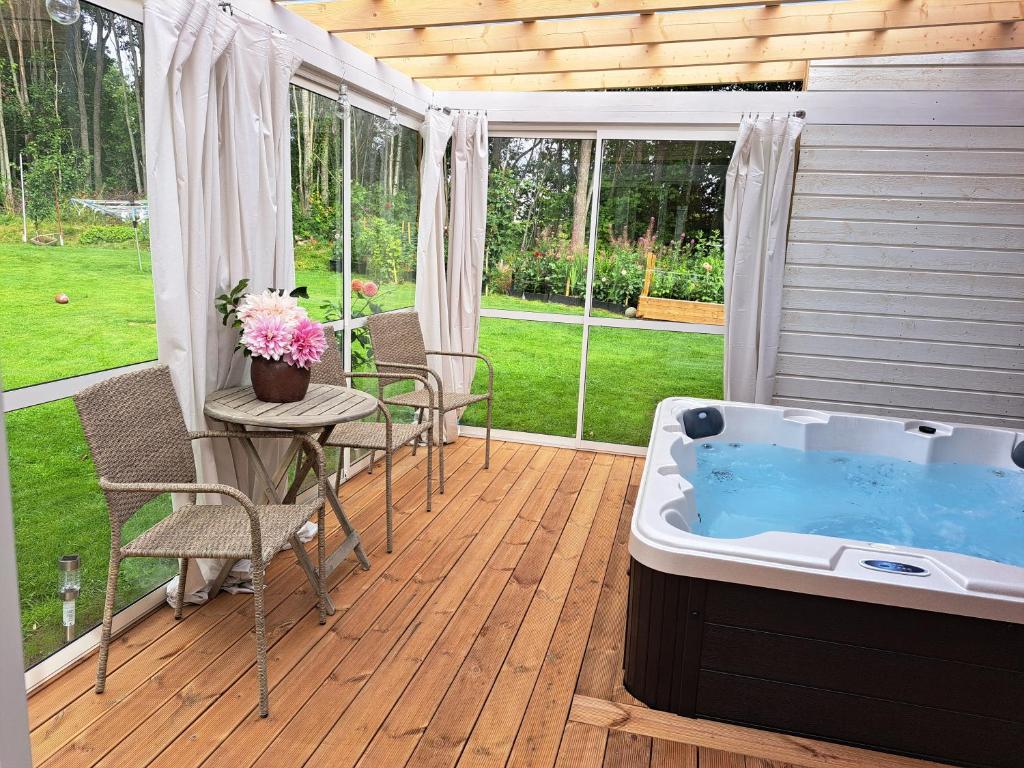 - un bain à remous sur une terrasse avec une table et des chaises dans l'établissement Myntloftet Borlänge med inglasad bubbelbad, à Borlänge