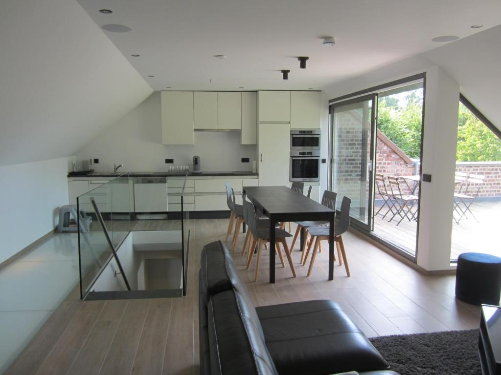 een keuken en eetkamer met een tafel en stoelen bij The Kettle House - Stable in Sint-Pieters-Leeuw