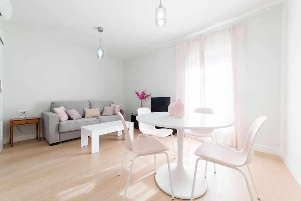 een witte woonkamer met een witte tafel en stoelen bij Casa Angeline Rosa 2 By KubiK in Cáceres