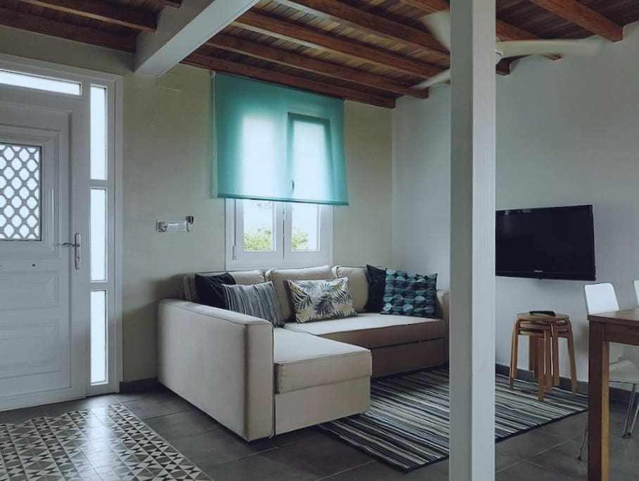 sala de estar con sofá y TV de pantalla plana en Casa cerca de la playa Casa da Cuncheira, en Carnota