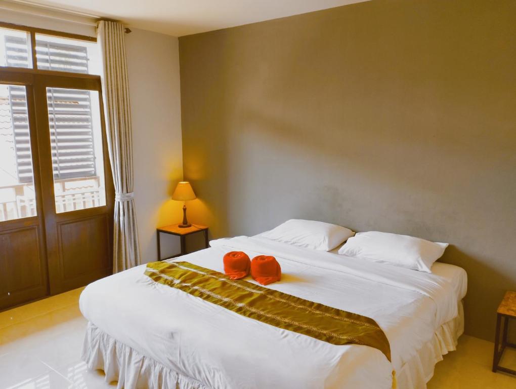 Un dormitorio con una gran cama blanca con dos cuencos rojos. en Laemdin Hotel, en Koh Samui 