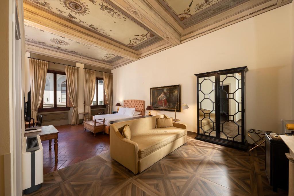 a living room with a couch and a bed at Palazzo Martellini Residenza d'epoca in Florence