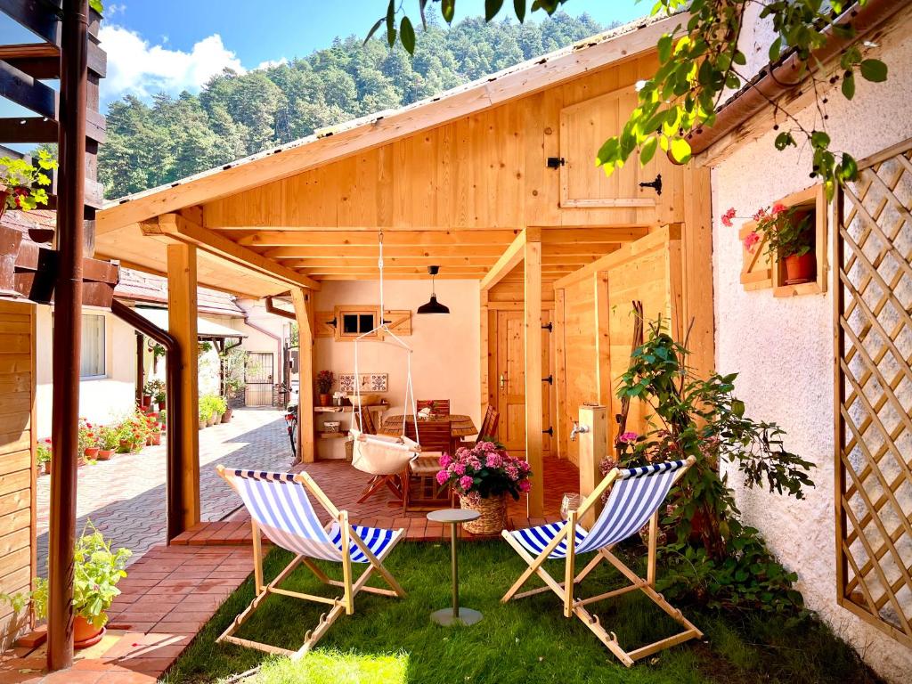 a patio with two chairs and a table at Victoria Gasthaus Rasnov - charming vacation house in Rasnov in Râşnov