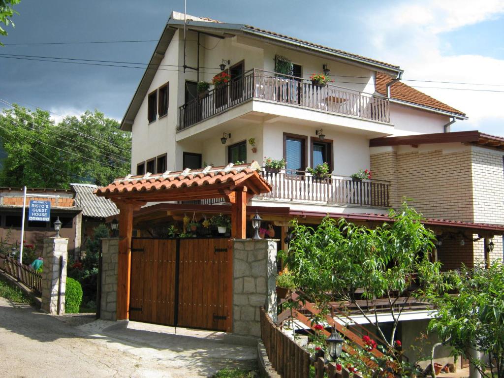 una casa con una puerta de madera y una valla en Risto's Guest House en Ohrid