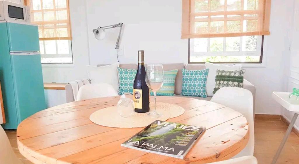 - une table à manger avec une bouteille de vin et un livre dans l'établissement Habanitas, à Santa Cruz de la Palma