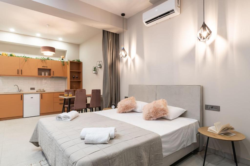 a bedroom with a large white bed and a kitchen at Bella Vacanza Studios in Zakynthos