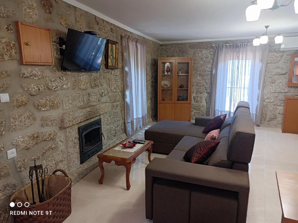uma sala de estar com um sofá e uma lareira em Casa Sambinho Gerês em Rio Caldo