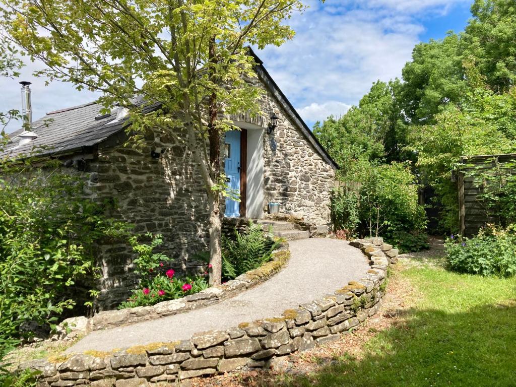 a stone house with a stone path leading to a window at Coedmor Cottages in Lampeter