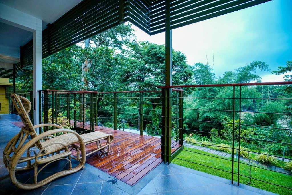 a screened in porch with a bench on a deck at Kuruva Island Resort And Spa - By KABINI BREEZE, Wayanad in Mananthavady