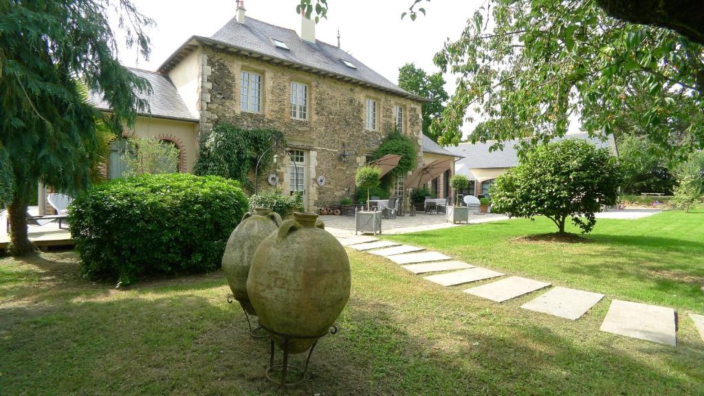 two large vases sitting in front of a house at Les Demeures de Marie in Pacé