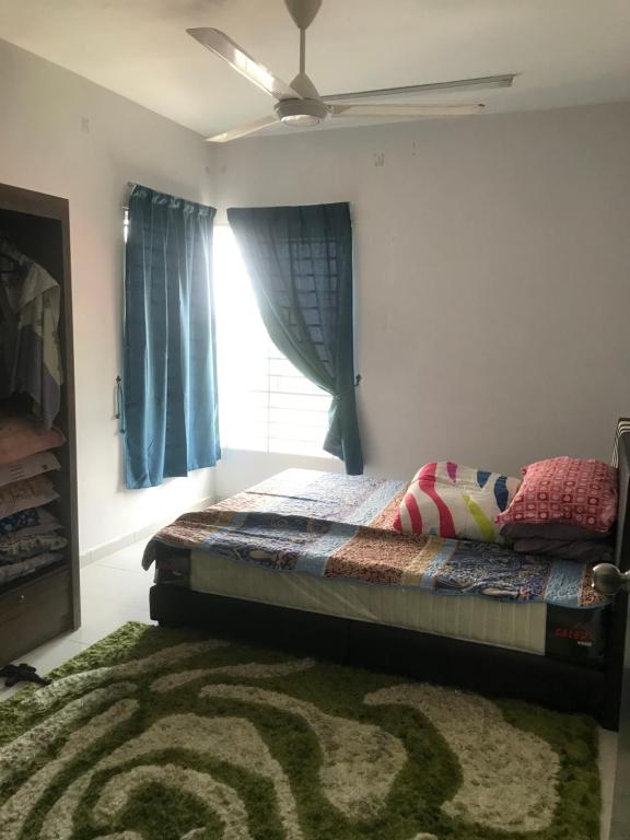a bedroom with a bed with a window and a rug at Homestay Ar Rayyan RESIDENSI LAGUNA BIRU in Rawang