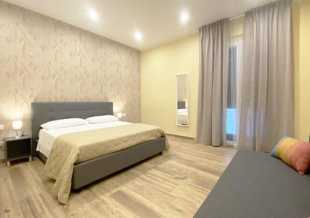 een slaapkamer met een groot bed en een groot raam bij Sami B&B and holidays home in Taranto