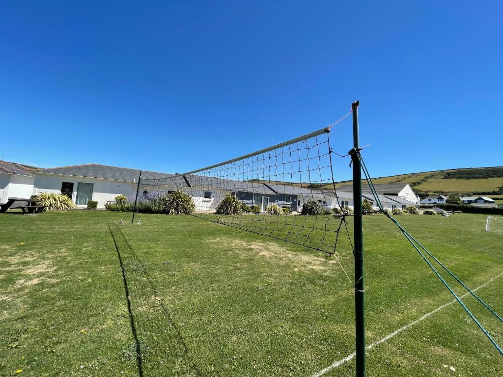 a net on a soccer field with a house at Croyde Bay Hotel or Self Catering in Croyde