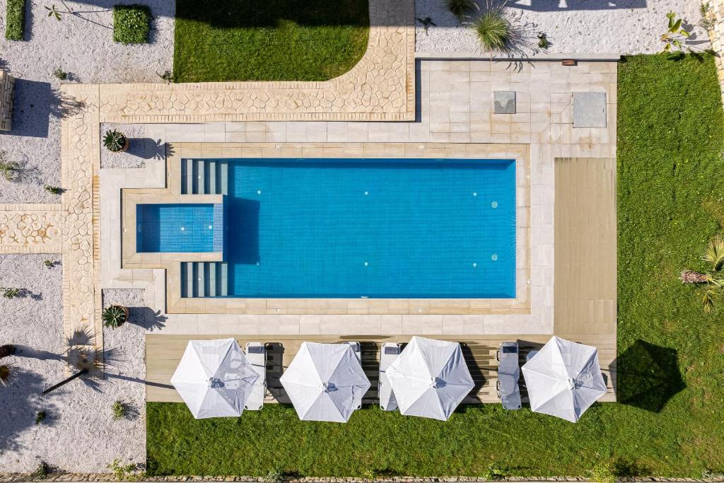 an overhead view of a swimming pool with umbrellas at Vita Residence, a Charming Family Escape,By ThinkVilla in Pangalochori