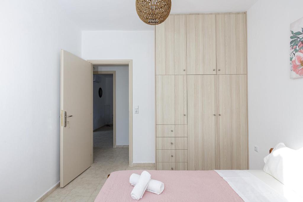 a bedroom with white walls and a bed with a pink blanket at Vita Residence, a Charming Family Escape,By ThinkVilla in Pangalochori