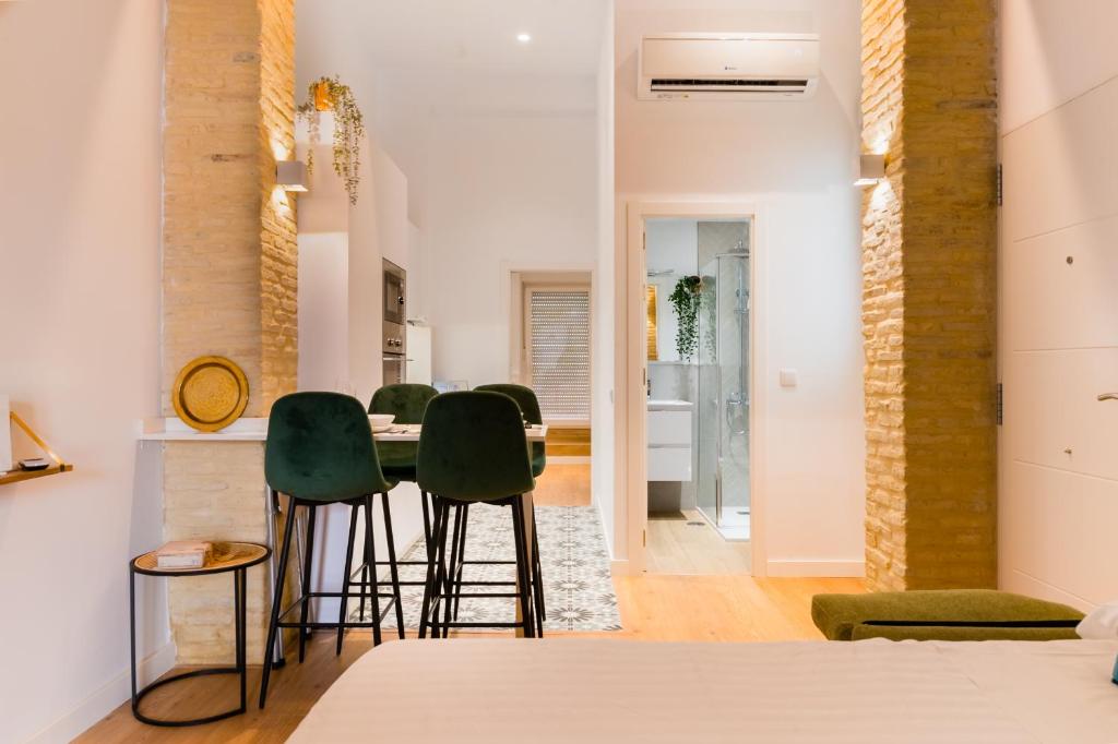 jadalnia z zielonymi krzesłami i stołem w obiekcie Diseño Triana 2 rooms w Sewilli