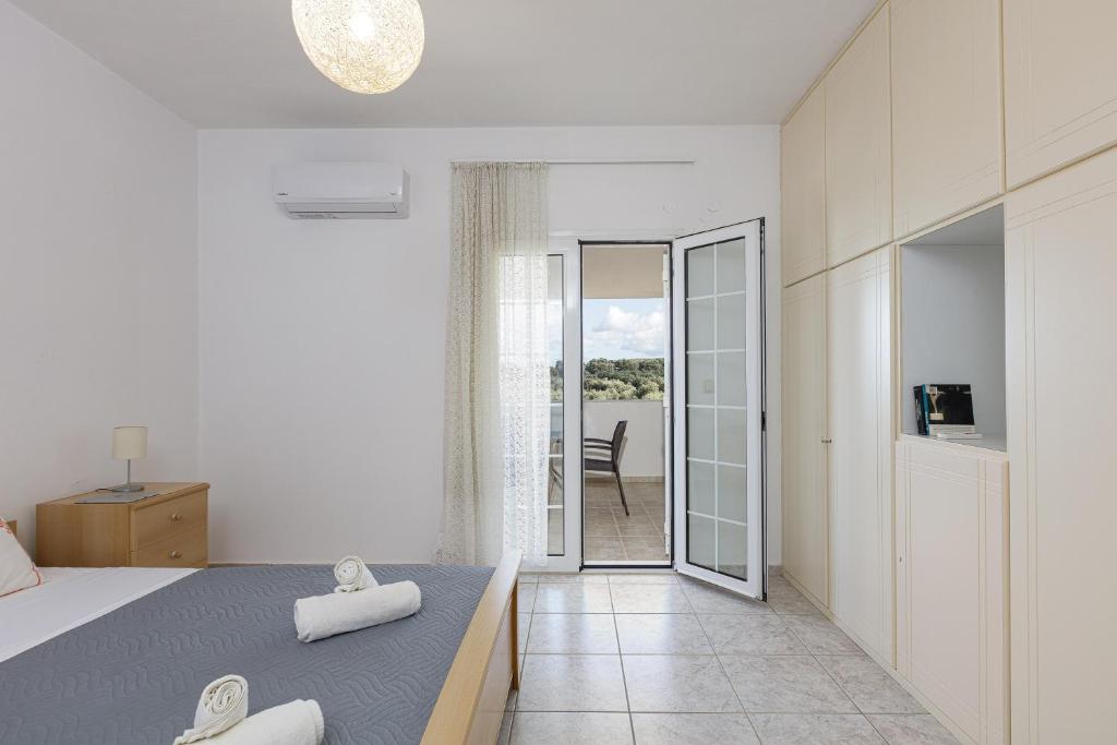 a white bedroom with a bed and a balcony at Vita Residence, a Charming Family Escape,By ThinkVilla in Pangalochori