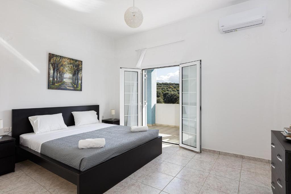 a bedroom with a bed and a balcony at Vita Residence, a Charming Family Escape,By ThinkVilla in Pangalochori