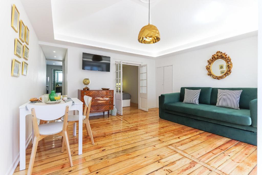 Una sala de estar con un sofá verde y una mesa. en Castelo Premium by Homing, en Lisboa