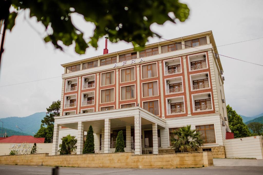 a large building with a red and white at Afra Oghuz Mountain Resort Hotel in Oğuz