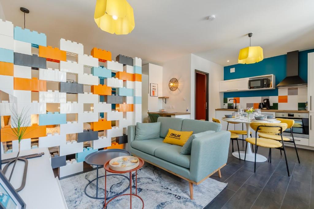 un salon avec un canapé et un mur de places dans l'établissement Mon Petit Sejour Lucon, à Luçon