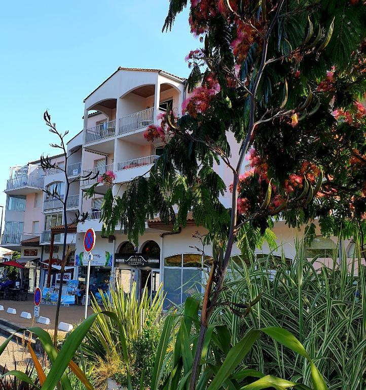 un grand bâtiment avec un arbre devant lui dans l'établissement Puytraud Mer, à Saint-Palais-sur-Mer