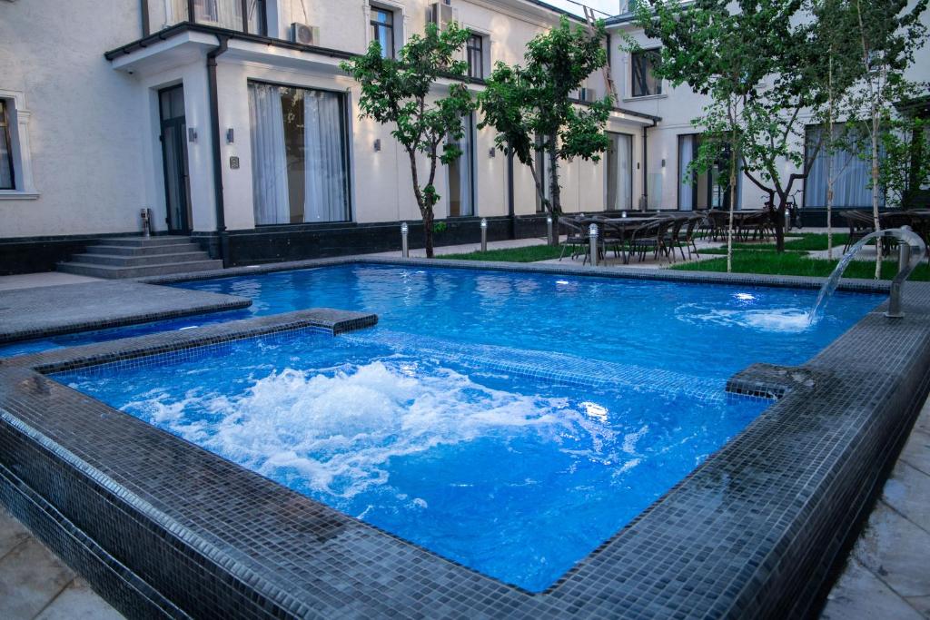 duży błękitny basen z fontanną w obiekcie Turon Lux Hotel w Samarkandzie