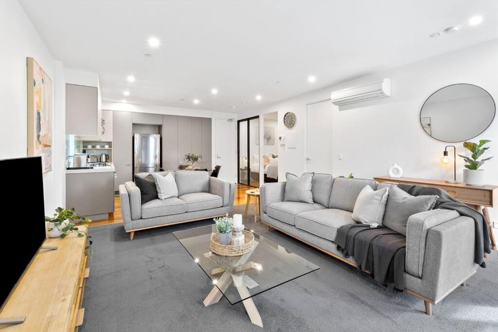 a living room with two couches and a table at Pier Point 404- Luxe on Geelong Waterfront, 2 BDRM in Geelong
