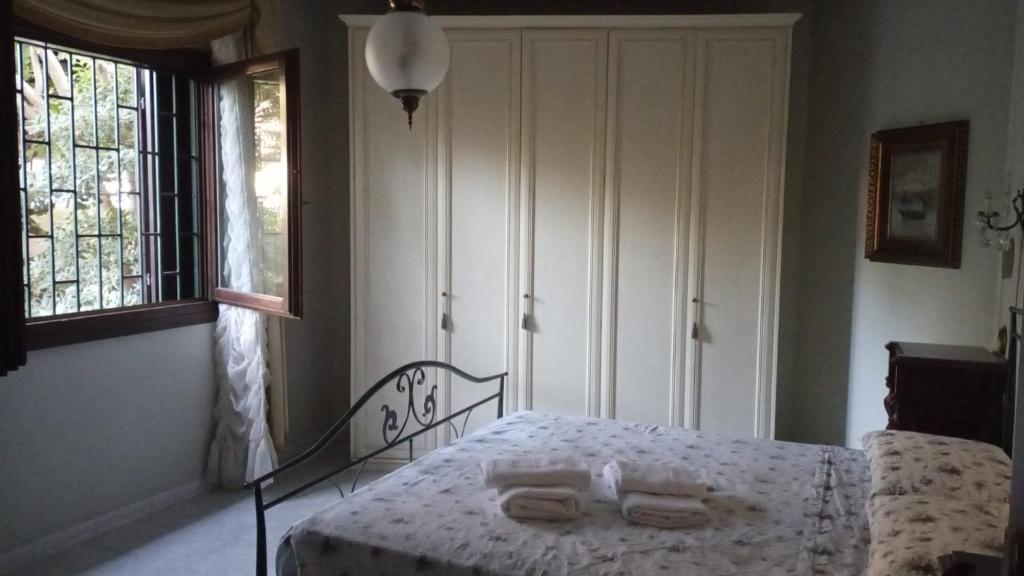 a bedroom with a bed with two towels on it at Domus Garden in Olbia